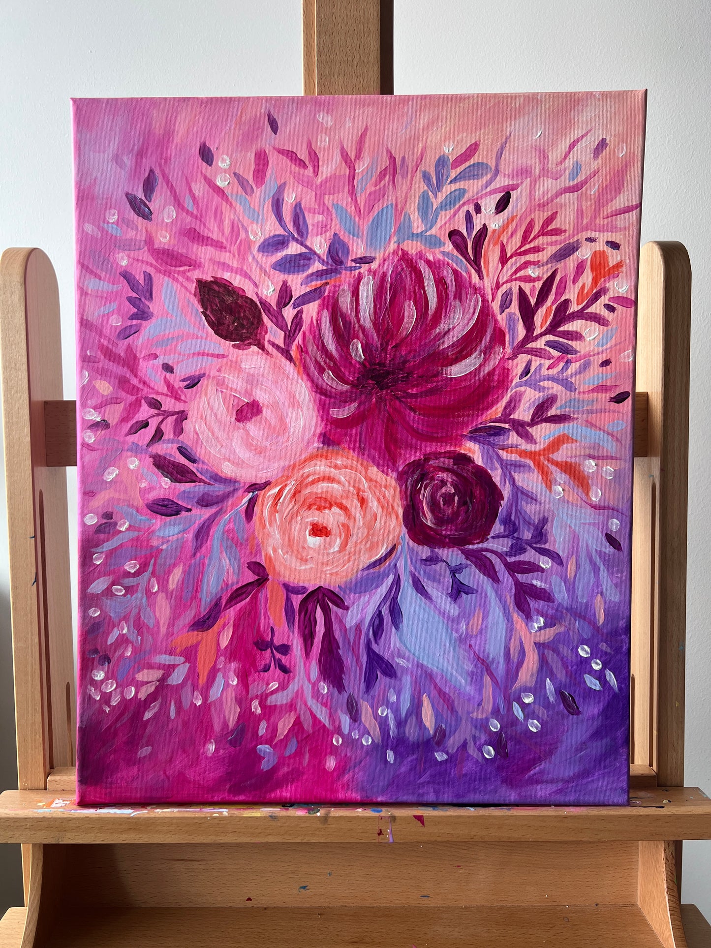 Floral painting on a wooden easel with a colorful abstract design.
