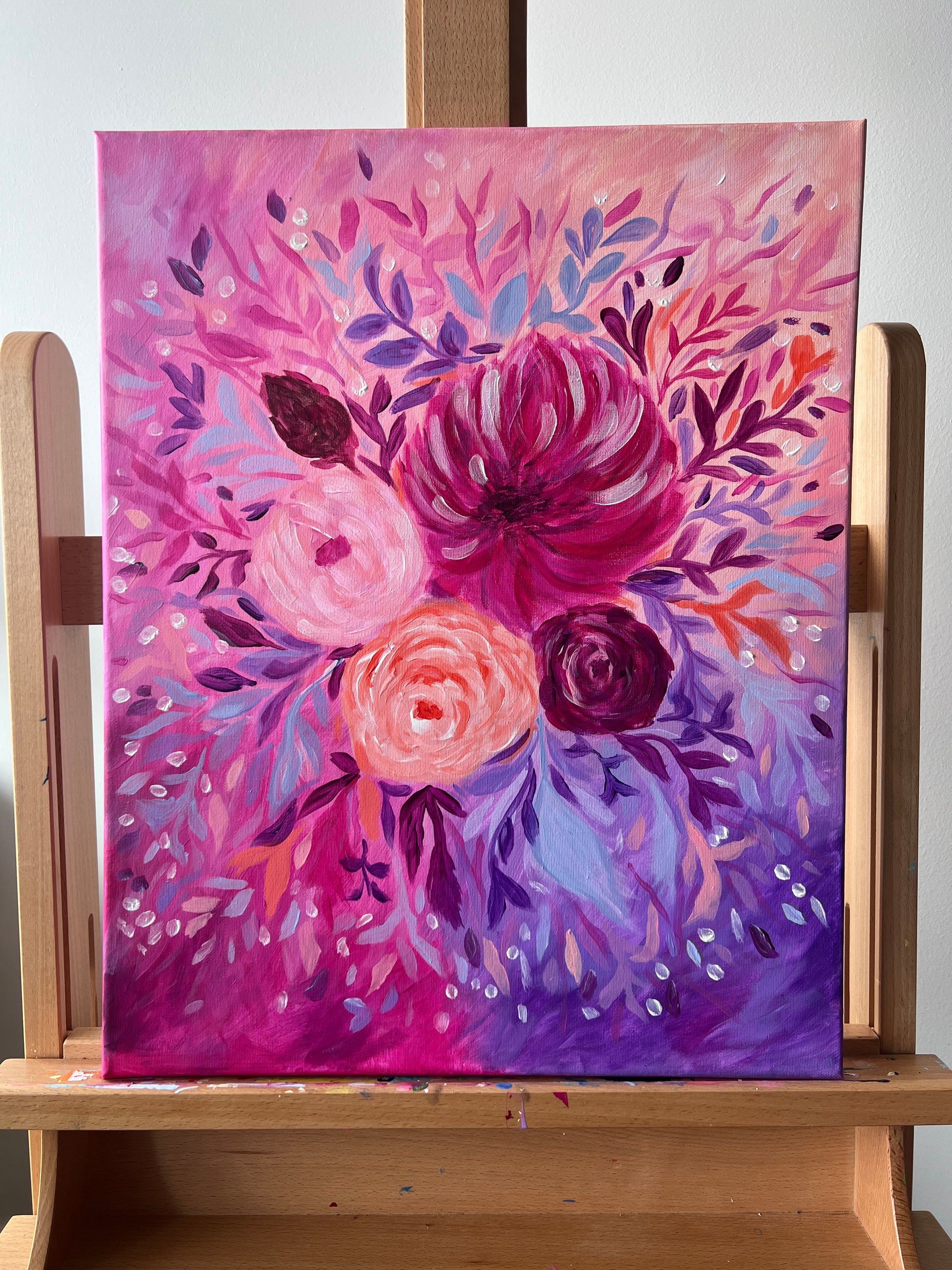 Floral painting on a wooden easel with a colorful abstract design.

