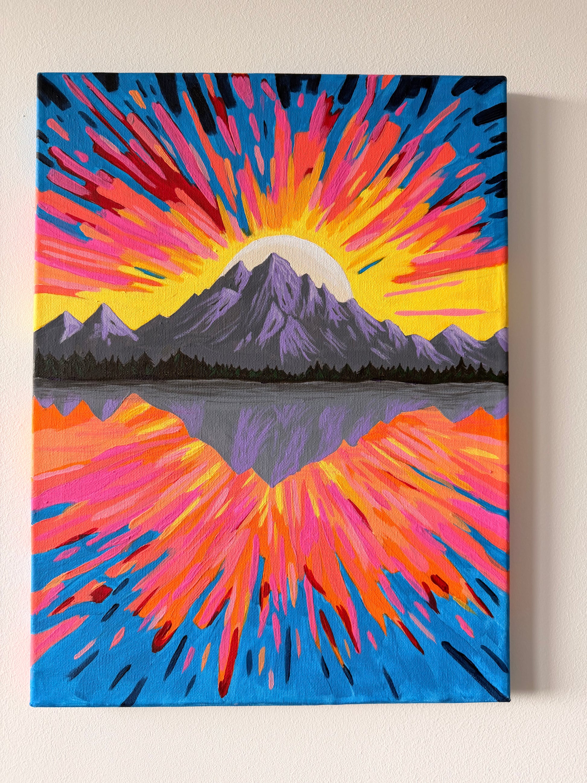 Colorful abstract painting of a mountain with a sunset effect on a beige wall.